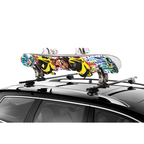 Colorful snowboard with bindings on a car roof rack against a white background