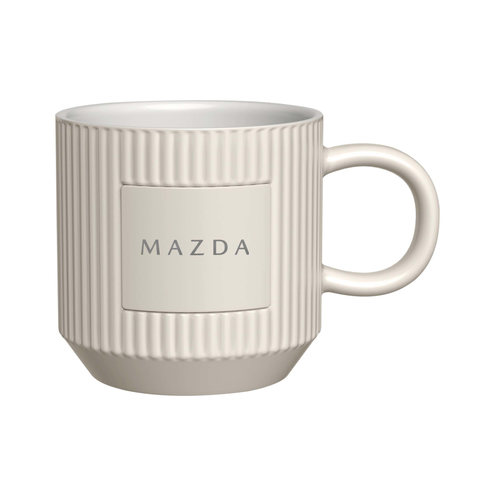 A white ceramic mug with a ribbed exterior, a central square panel, and the word 'MAZDA' printed in gray on the front, shown on a plain white background.