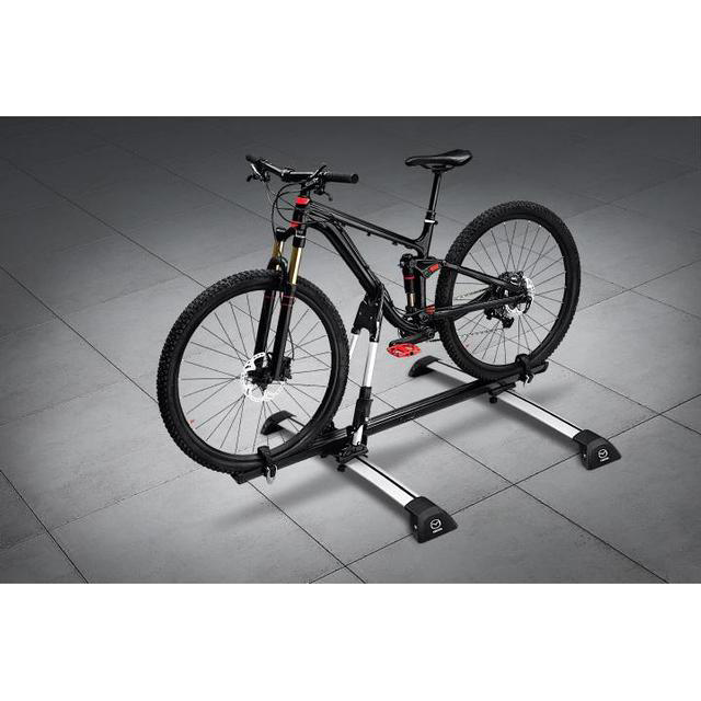 Bicycle on a stand against a gray tiled wall